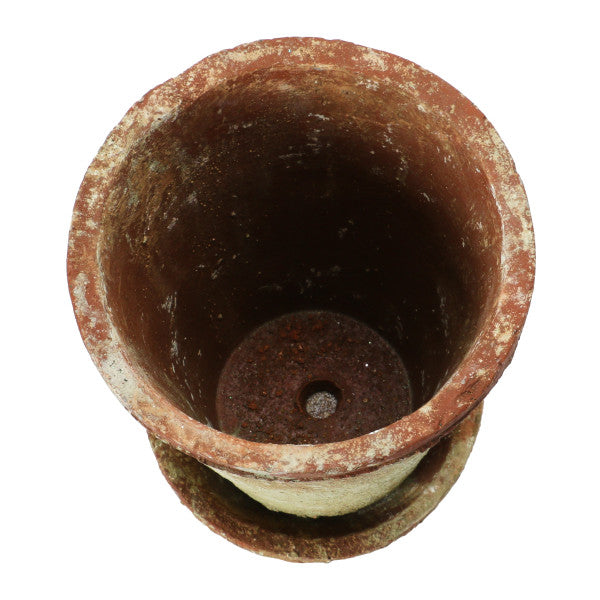 A round terracotta cement planter with a distressed finish and a saucer.